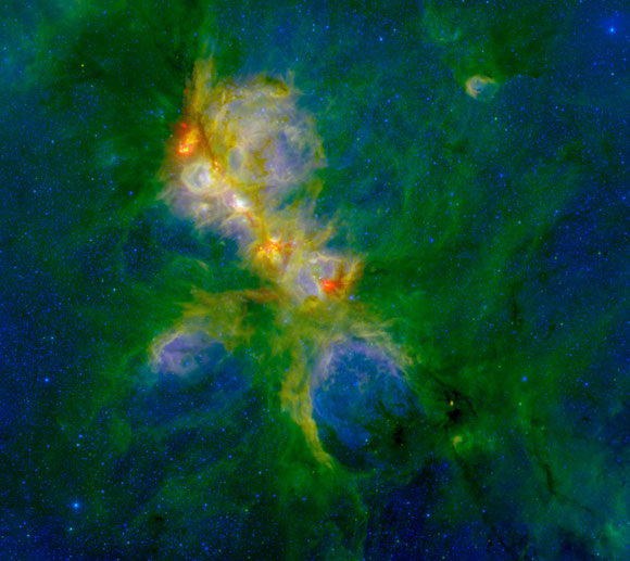 Immagine di NGC 6334 ottenuta combinando i dati infrarossi dei telescopi spaziale Spitzer e Herschel con quelli ottenuti da terra con il telescopio Blanco da 4 metri di apertura dell’osservatorio di Cerro Tololo (Cile). (Crediti: ESA/Herschel; NASA/JPL-Caltech/SSC; CTIO/NOAO/AURA/NSF)