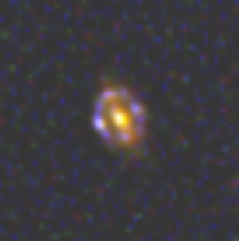 Immagine a falsi colori della più distante lente cosmica conosciuta, ovvero una galassia a 9.4 miliardi di anni luce da noi. L'immagine è stata ottenuta dalla combinazione di riprese degli strumenti WFC3 e ACS del telescopio spaziale Hubble. Crediti: HST/NASA/ESA/, van der Wel et al.