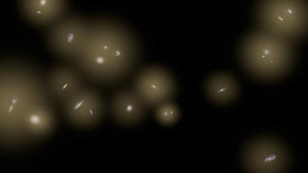 Riproduzione artistica di un gruppo di galassie circondate da enormi aloni di stelle. Le stelle sono troppo lontane per essere viste individualmente e quindi vengono rappresentate come un bagliore diffuso di colore giallo. L'esperimento razzo CIBER ha rilevato questo bagliore agli infrarossi. Crediti: NASA/JPL-Caltech