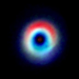 L’immagine del sistema binario HD 142527 ottenuta dai dati acquisiti da ALMA mostra un arco di polvere (in rosso) e un anello di monossido di carbonio (blu e verde). L'arco è privo di gas, indicando che il monossido di carbonio si sarebbe "congelato" formando uno strato di brina sui grani di polvere. Gli astronomi ritengono che questo strato ghiacciato fornisca una spinta alla formazione planetaria. I due punti al centro rappresentano le due stelle del sistema. Crediti: Andrea Isella/Rice University; B. Saxton/NRAO/AUI/NSF; ALMA/NRAO/ESO/NAOJ
