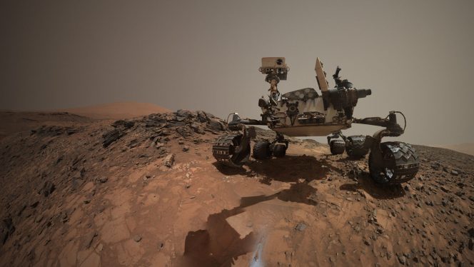 Il selfie del rover NASA Curiosity, sul sito marziano dove è stato raccolto un campione della roccia chiamata Buckskin. Circondata da un ciuffo di polvere iridescente, la foratura nel suolo marziano è ben visibile in primo piano. Crediti: Crediti: NASA / JPL-Caltech / MSSS.