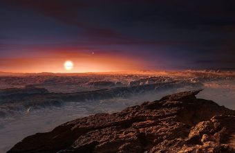 Rappresentazione di fantasia della superficie del pianeta Proxima b, recentemente scoperto in orbita attorno alla stella nana rossa Proxima Centauri, l’astro più vicino al sistema solare. Sulla superficie della stella sarebbero periodicamente visibile delle gigantesche macchie stellari. Crediti: ESO/M. Kornmesser