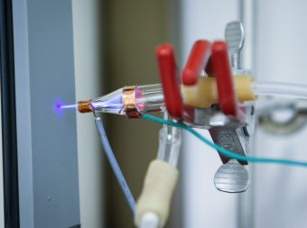 La stampante a getto di plasma è costituita da un ugello di vetro con due elettrodi di rame collegati ad un alimentatore. Crediti: Universities Space Research Association at NASA Ames Research Center